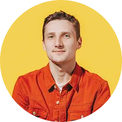 Portrait of a young man with short hair wearing an orange jacket against a yellow background.